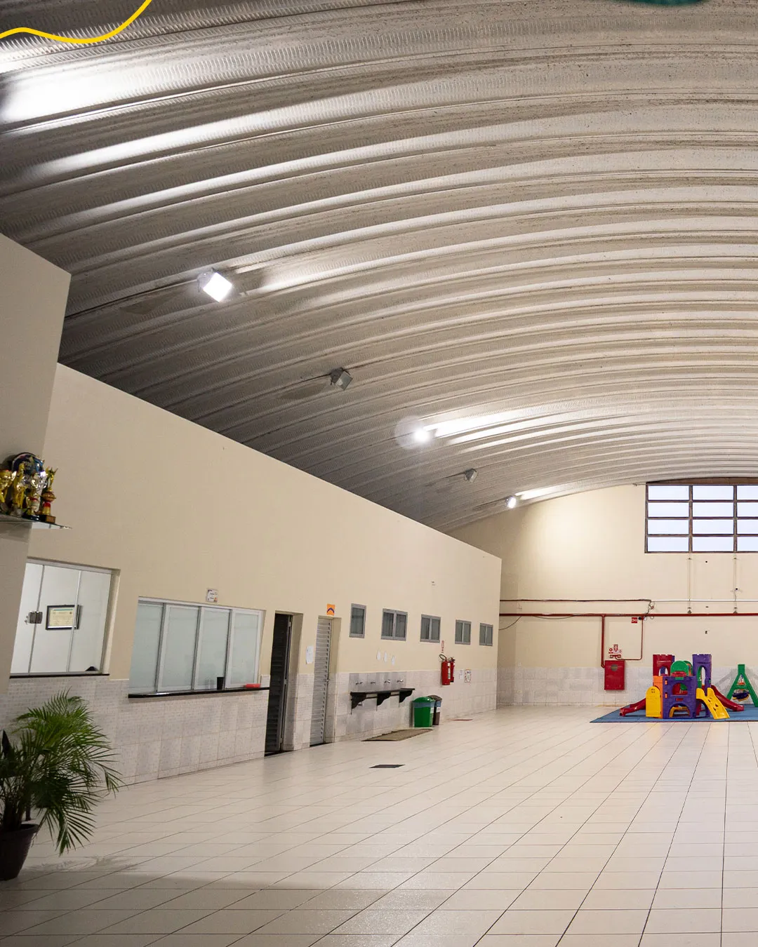 Pátio coberto da Coopercamp com brinquedos e espaço para o recreio